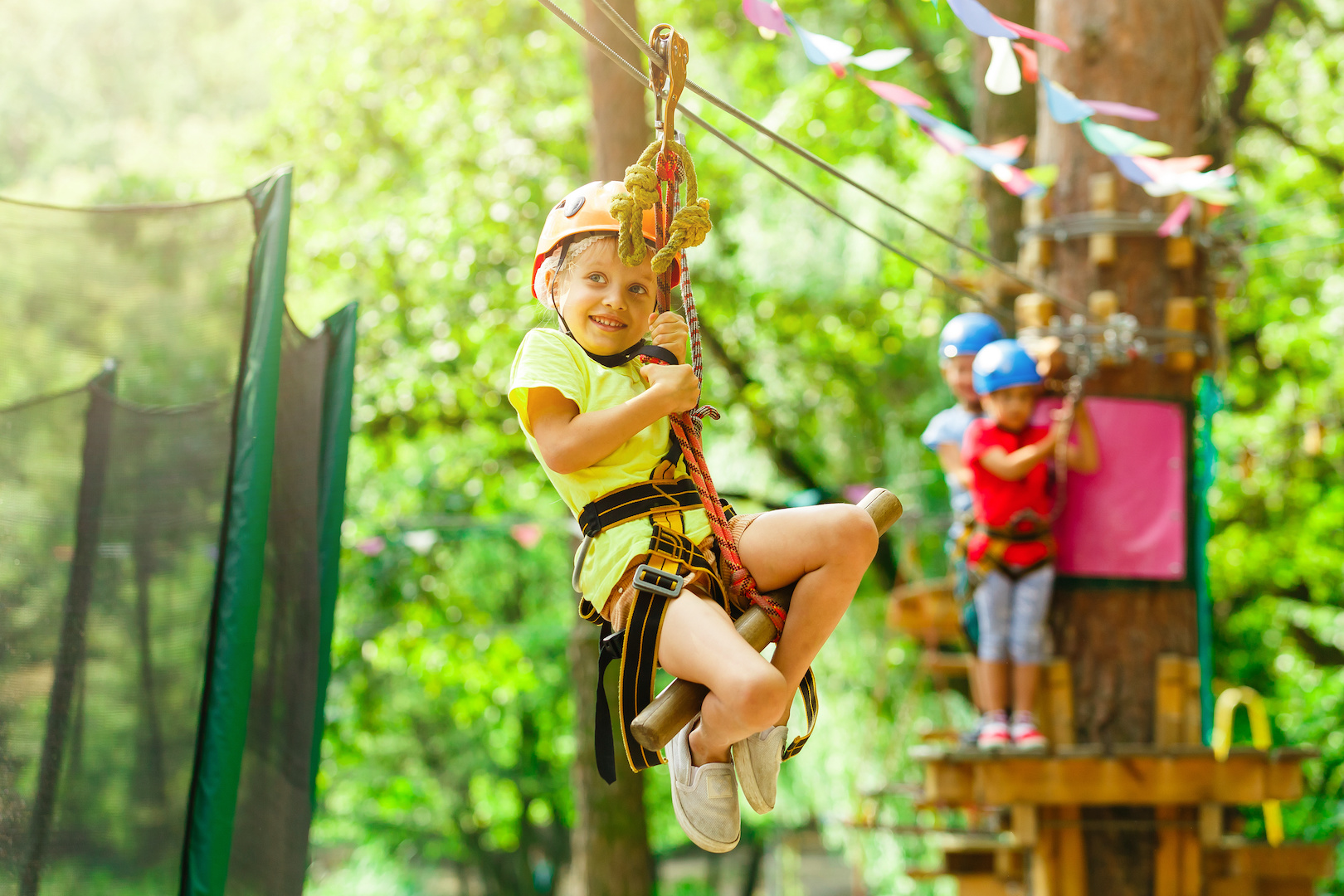 An der Zip-Line hängend geht es durch das dichte Grün der Baumwipfel.