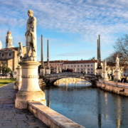 Zentrum des Prato della Valle ist eine Insel, die von einem Wasserkanal mit vier Brücken und 78 Statuen umrundet wird; im Hintergrund die Basilica di Santa Giustina.