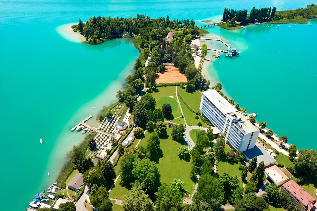Das Parkhotel liegt unmittelbar am Wörthersee und schmiegt sich so an das türkisgrüne Wasser.