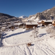 Herrlicher Blick auf das verschneite Sauris di Sotto mit seinen typischen Häusern aus Holz und Stein.